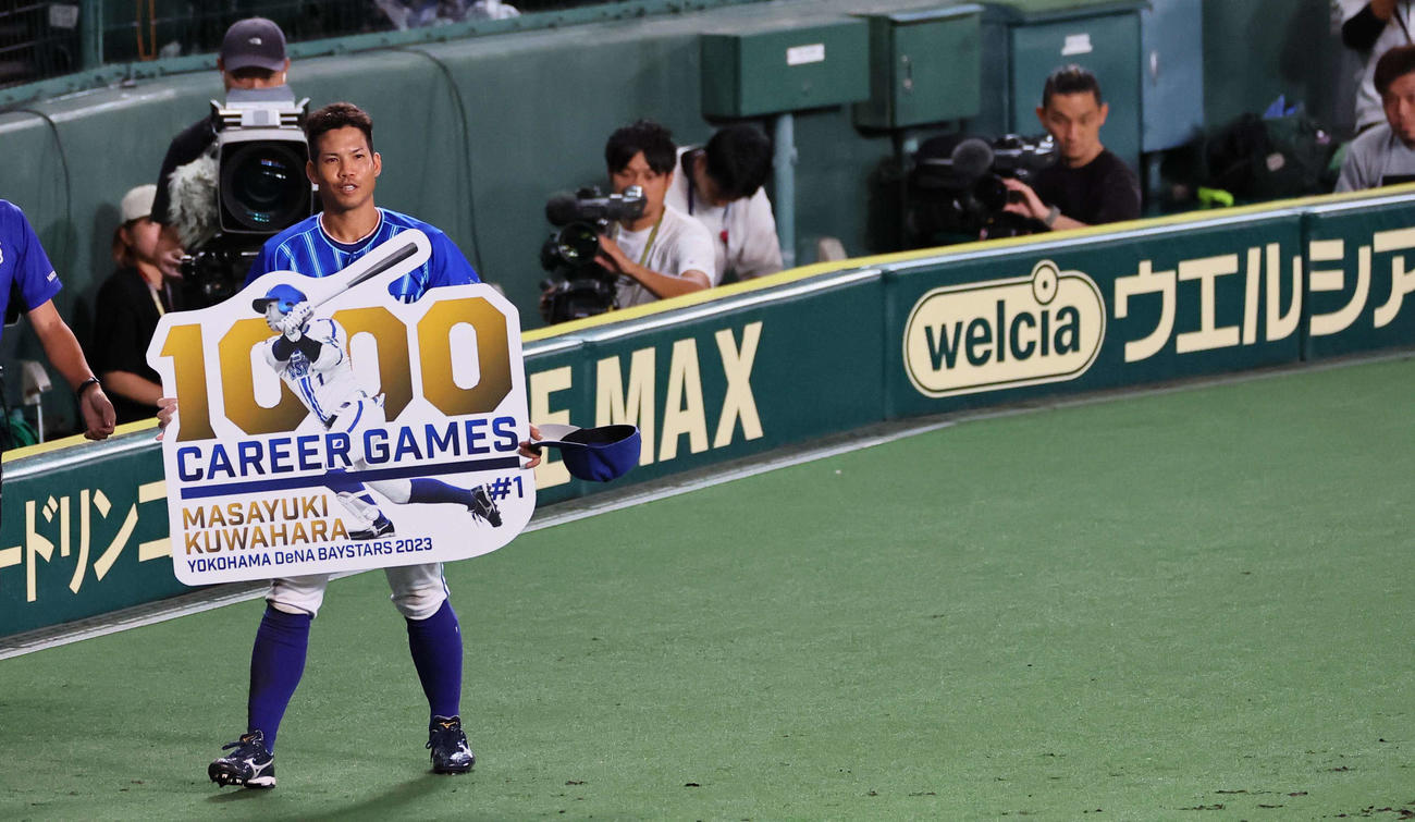 阪神対DeNA 5回、1000試合出場を果たした桑原将志はパネルを手に笑顔見せる（撮影・上田博志）