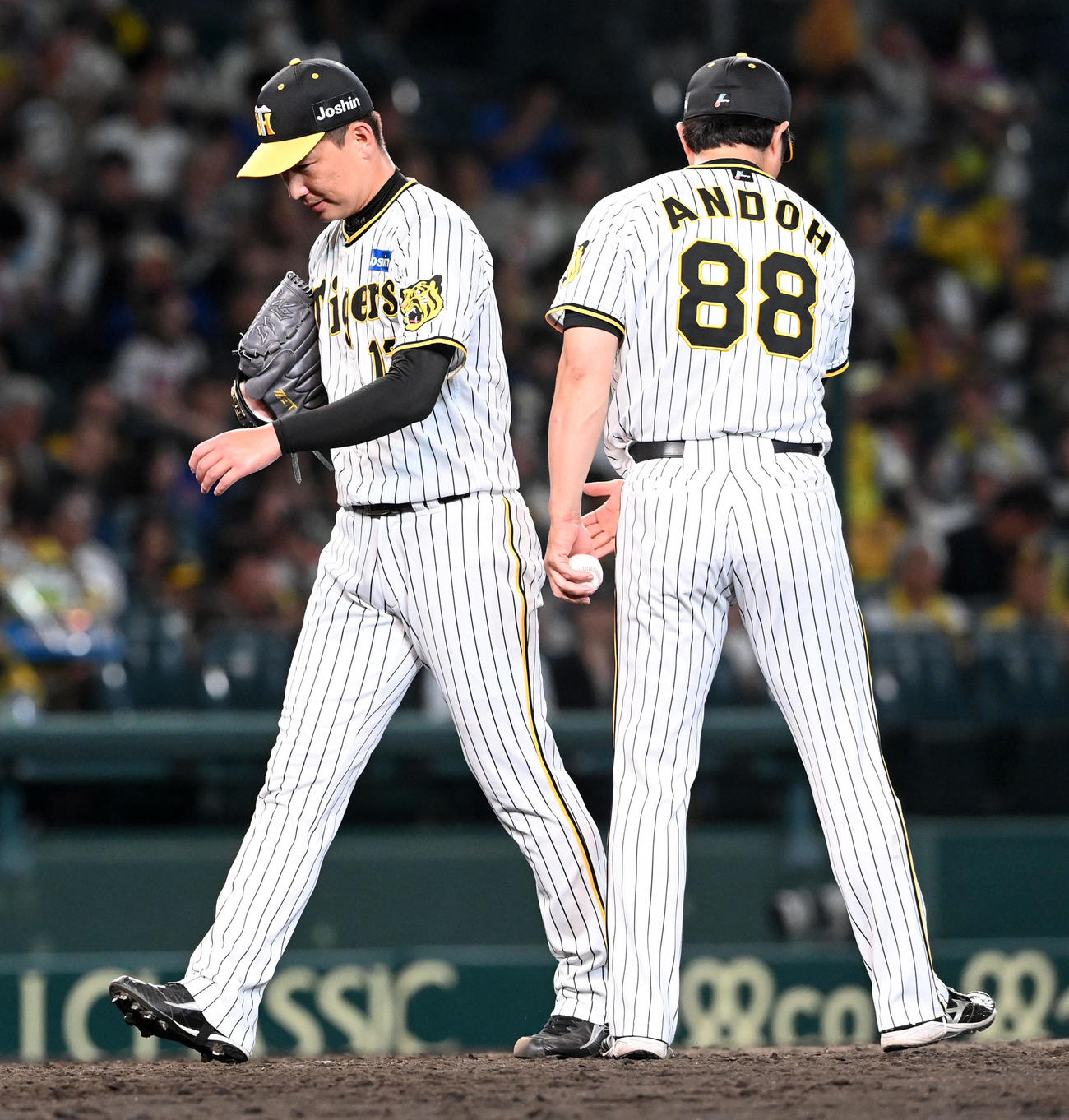 阪神対DeNA 9回、連続被弾でDeNAに逆転を許し、降板でベンチに下がる岩崎（左）。右は安藤コーチ（撮影・前岡正明）