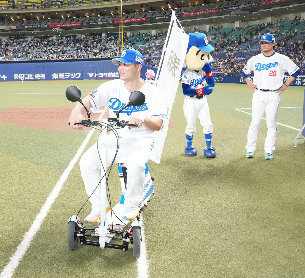 中日対ヤクルト　ヴィクトリーショーでドアラが使用するバイクにまたがグラウンドを一周する細川（左）（撮影・森本幸一）