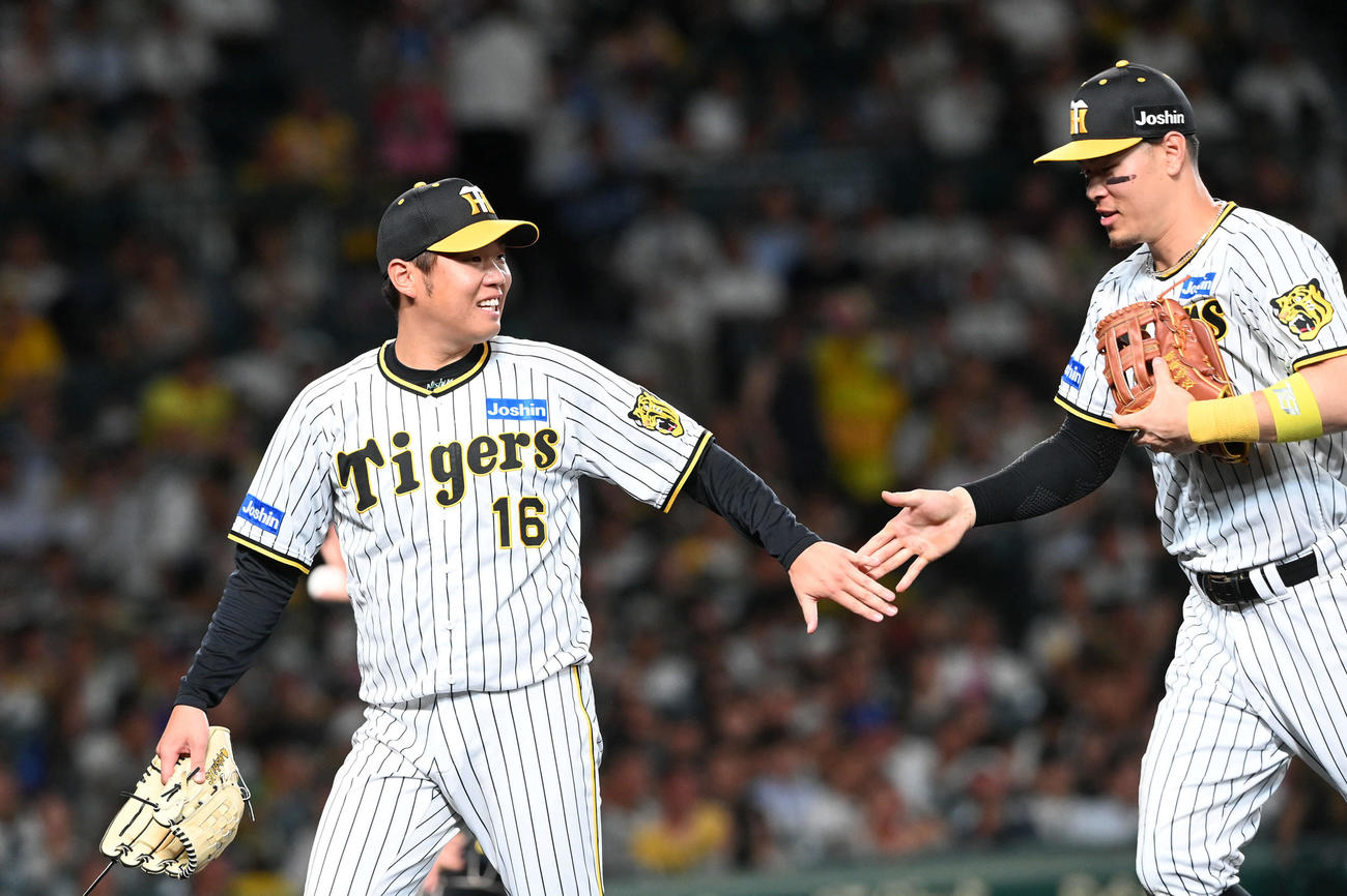 阪神対DeNA 6回、佐藤輝（右）と笑顔でタッチを交わす阪神先発の西勇（撮影・前岡正明）