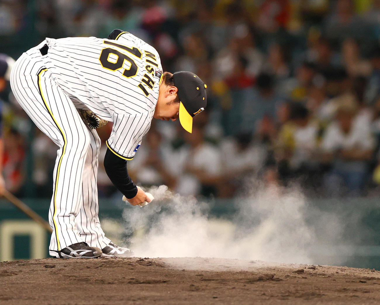 阪神対DeNA 4回表を前に、マウンドのプレートにロジンをつける阪神西勇（撮影・上山淳一）