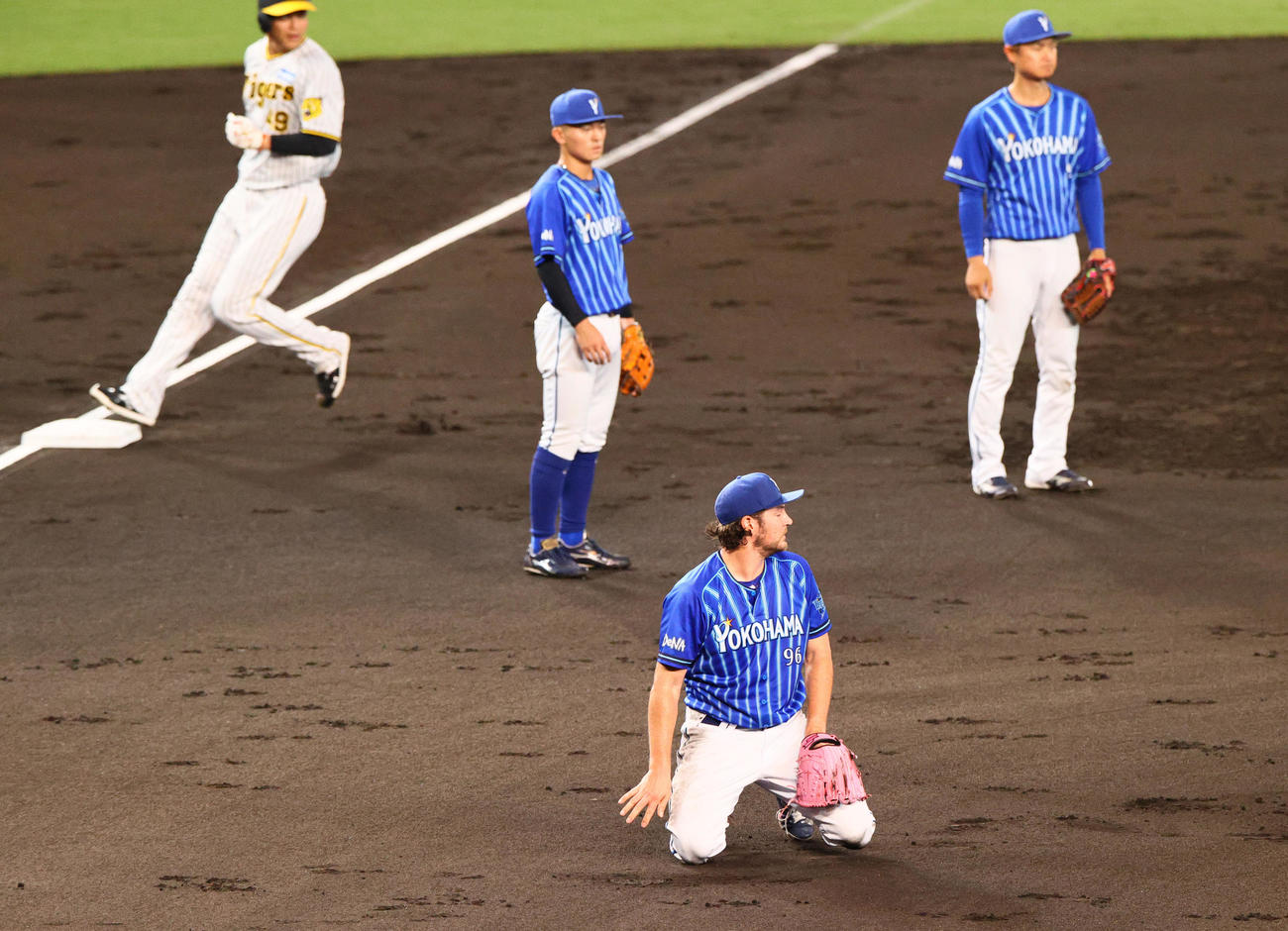 阪神対DeNA 3回裏阪神1死一塁、バウアー（手前）は近本の投前の打球を取り一塁へ懸命に送球も悪送球となる（撮影・上山淳一）