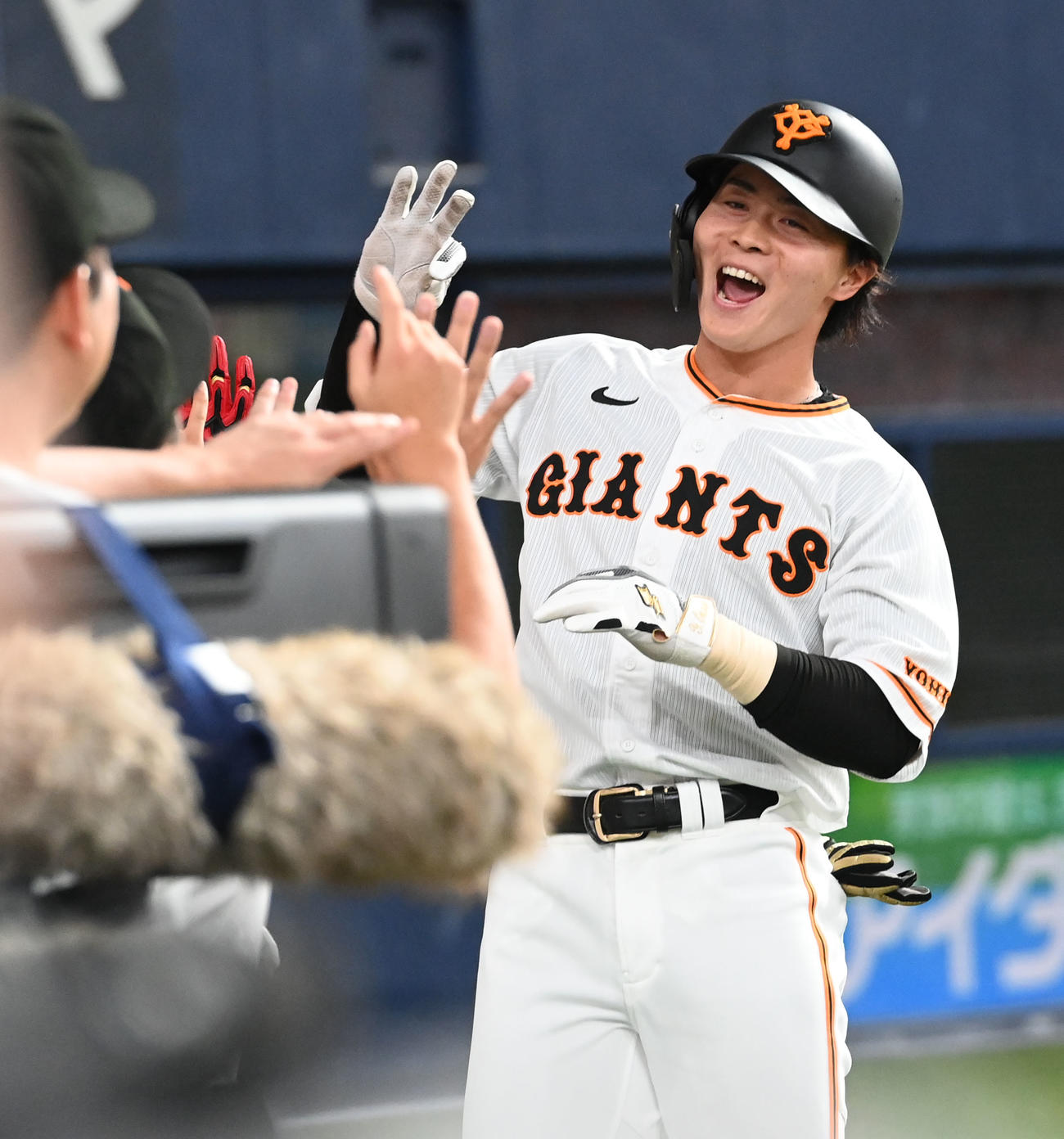 巨人対広島　9回裏巨人無死、右越え本塁打を放った岡田はベンチ前でナインとタッチ（撮影・和賀正仁）