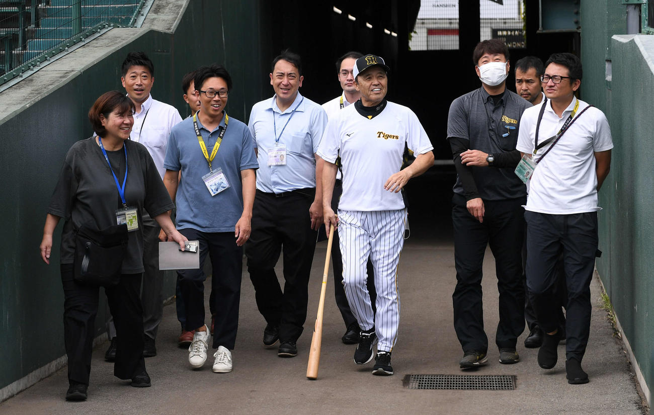 記者と談笑しながらグラウンドに向かう岡田監督（撮影・前岡正明）