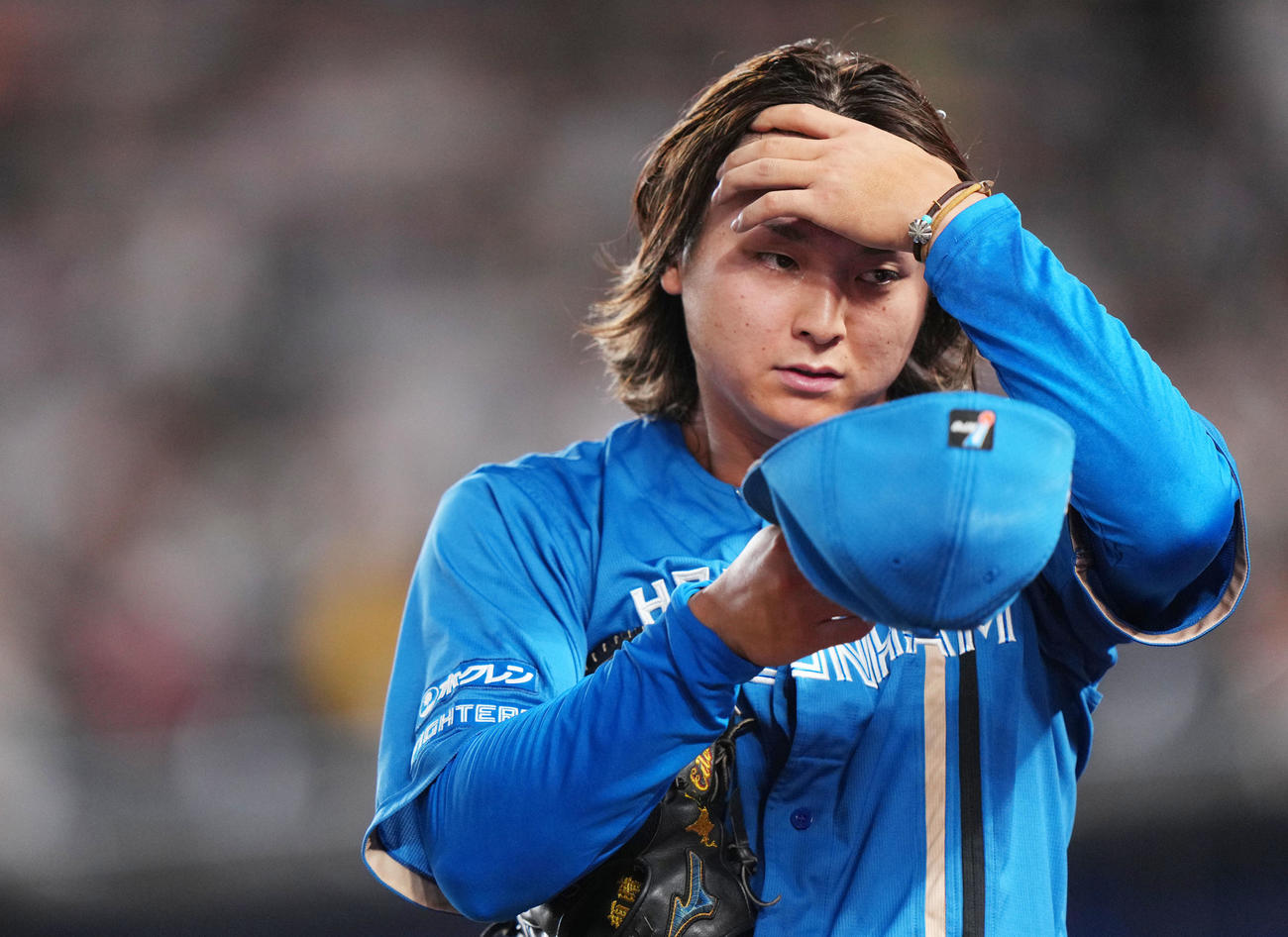 ロッテ対日本ハム　2回裏を終え、髪をかき上げ引き揚げる日本ハム田中瑛（撮影・横山健太）