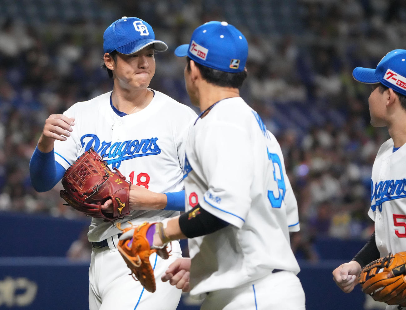 中日対ヤクルト　5回表終了、ナインとタッチを交わしベンチへ戻る中日先発の梅津（左）（撮影・森本幸一）
