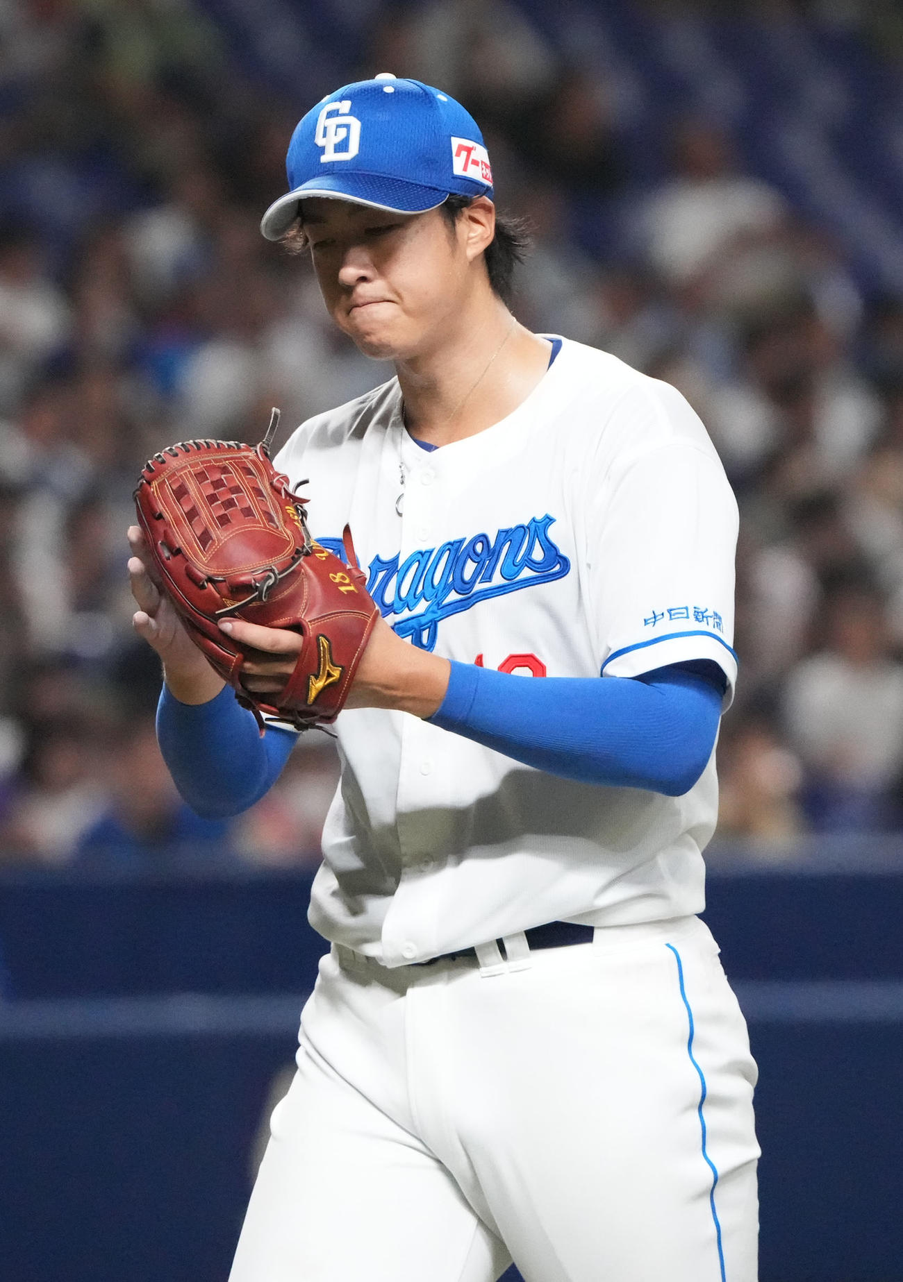 中日対ヤクルト　3回表終了、グラブを叩きベンチへ戻る中日先発の梅津（撮影・森本幸一）