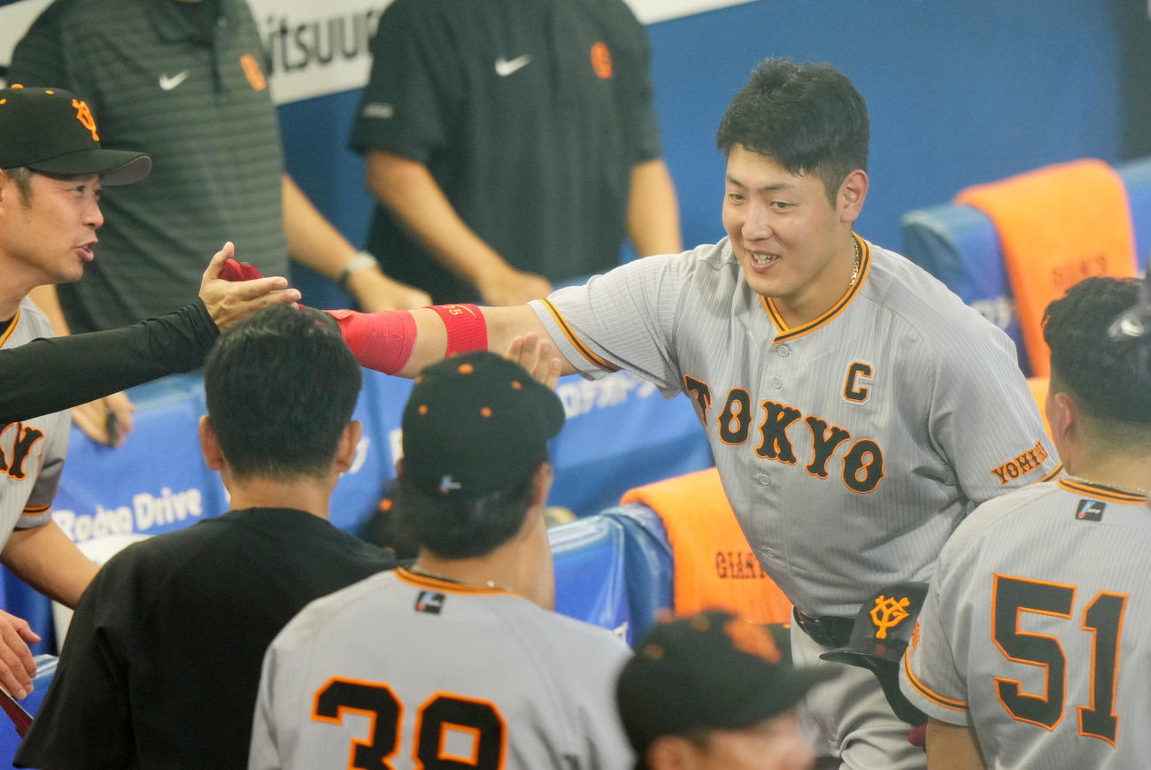 DeNA対巨人　2回表巨人無死、右越え本塁打を放った岡本和は通算200本塁打を達成し笑顔でナインとタッチを交わす（撮影・横山健太）