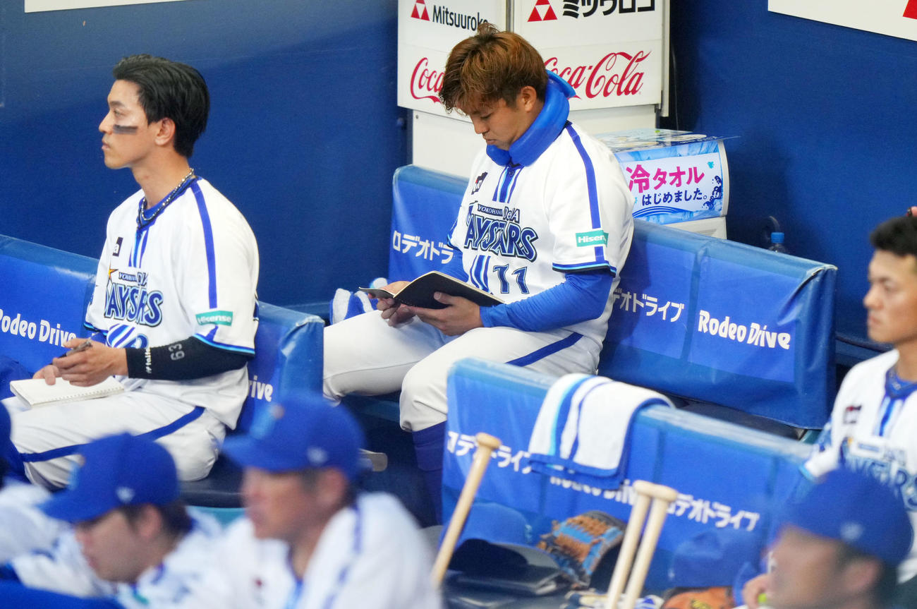 DeNA対巨人　ベンチでノートを見つめるDeNA東（中央）（撮影・横山健太）