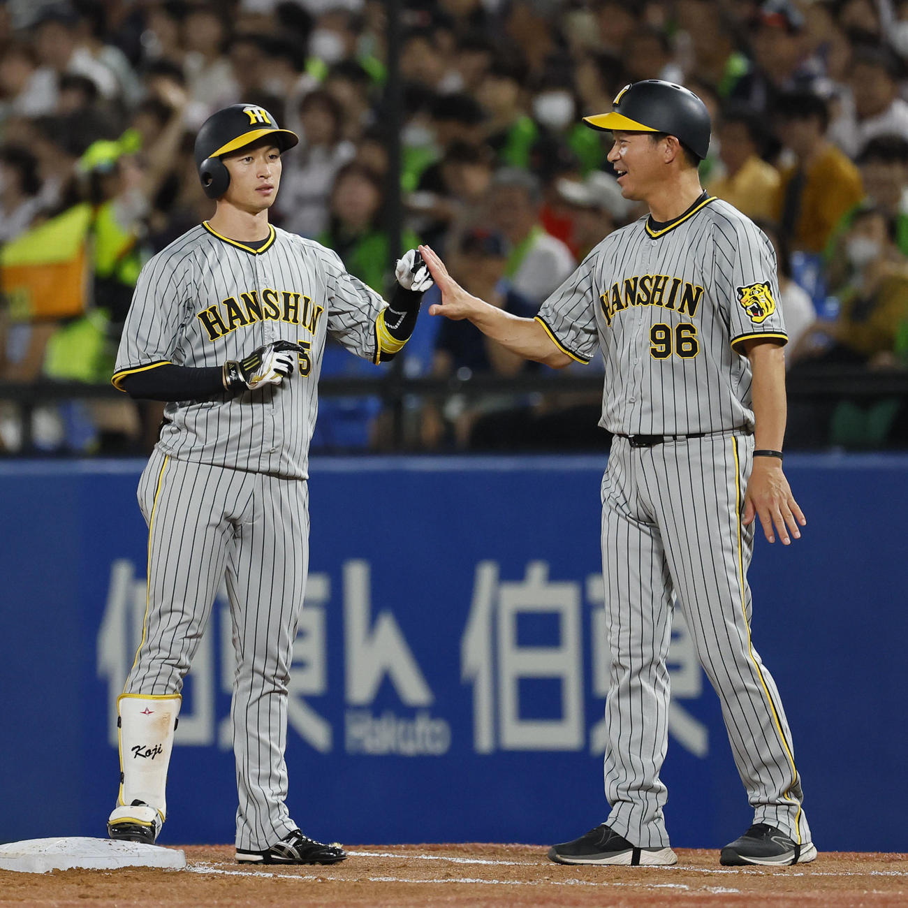 ヤクルト対阪神　3回表阪神2死二塁、右前に適時打を放ちコーチとタッチを交わす近本（左）（撮影・藤尾明華）