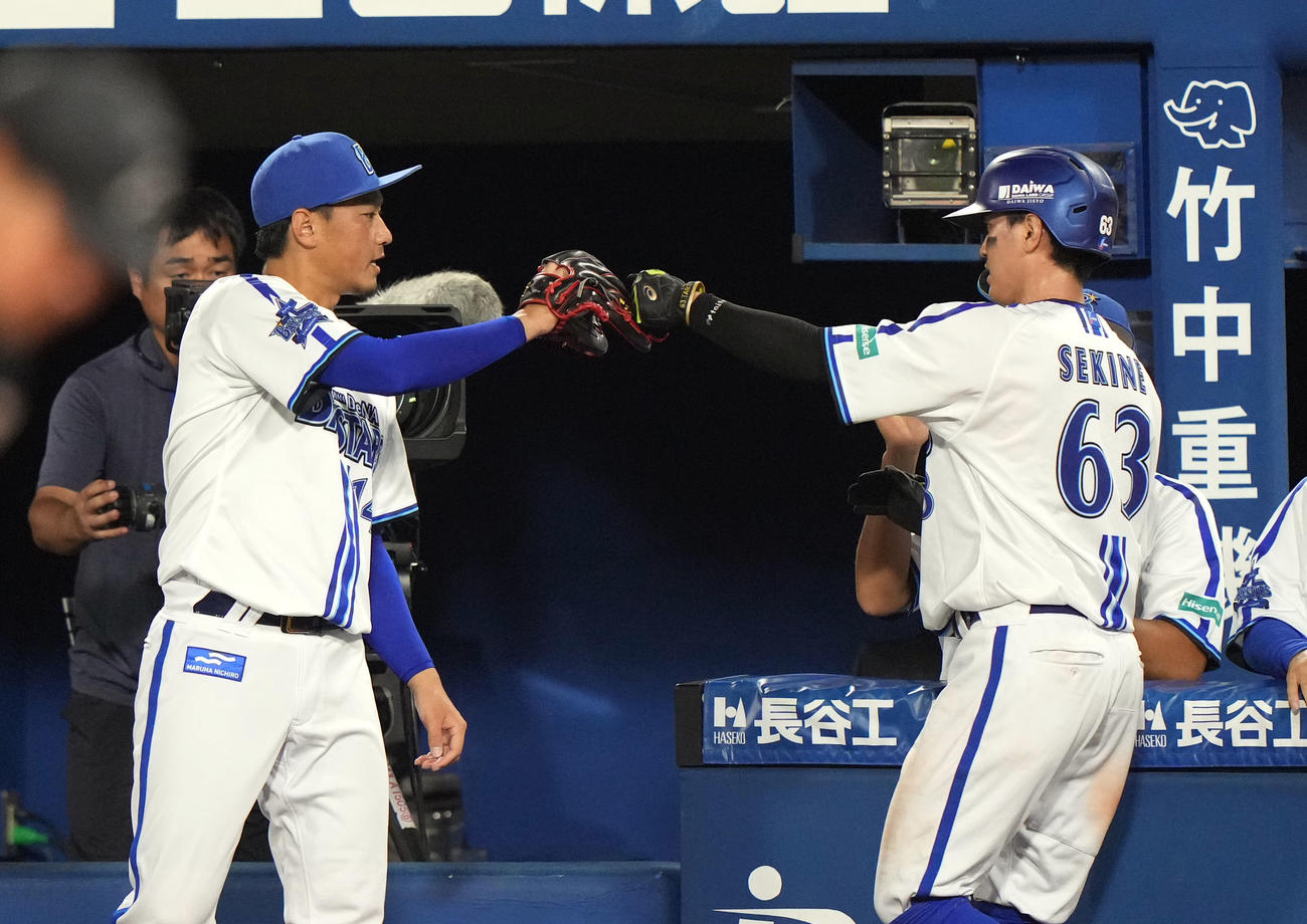 DeNA対巨人　2回裏DeNA2死一、二塁、宮崎敏郎の適時打で生還した関根とタッチを交わす石田（撮影・狩俣裕三）