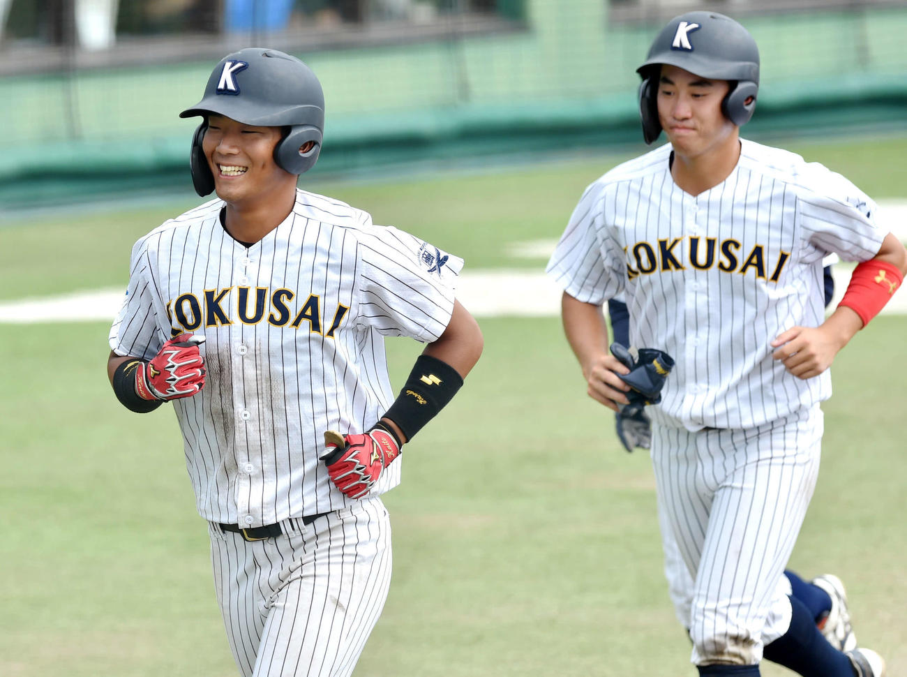 山形大対東日本国際大　4回裏東日本国際大2死一、三塁、3点右越え本塁打を放ち、笑顔でベンチに引き揚げる黒田（左）（撮影・相沢孔志）