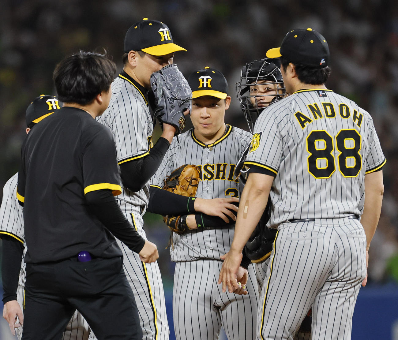 ヤクルト対阪神　9回裏ヤクルト無死、岩崎（左から2人目）は松本の打球を左手に受け、安藤コーチ（右）らと話し合う（撮影・藤尾明華）