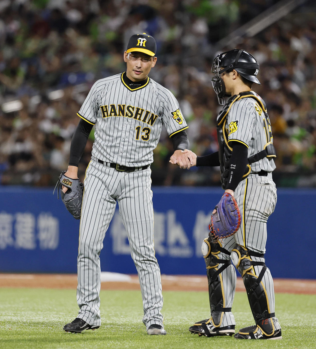 ヤクルト対阪神　9回を抑え坂本（右）とタッチを交わす阪神岩崎（撮影・藤尾明華）