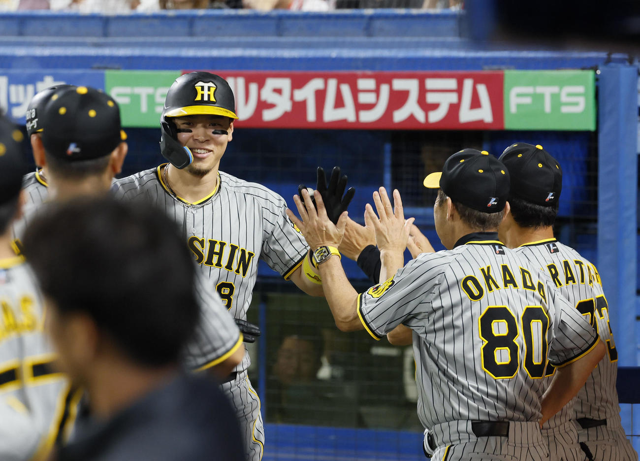 ヤクルト対阪神　3回表阪神2死一、三塁、佐藤輝（右から3人目）は右越え3点本塁打を放ち、岡田監督らに迎えられる（撮影・藤尾明華）