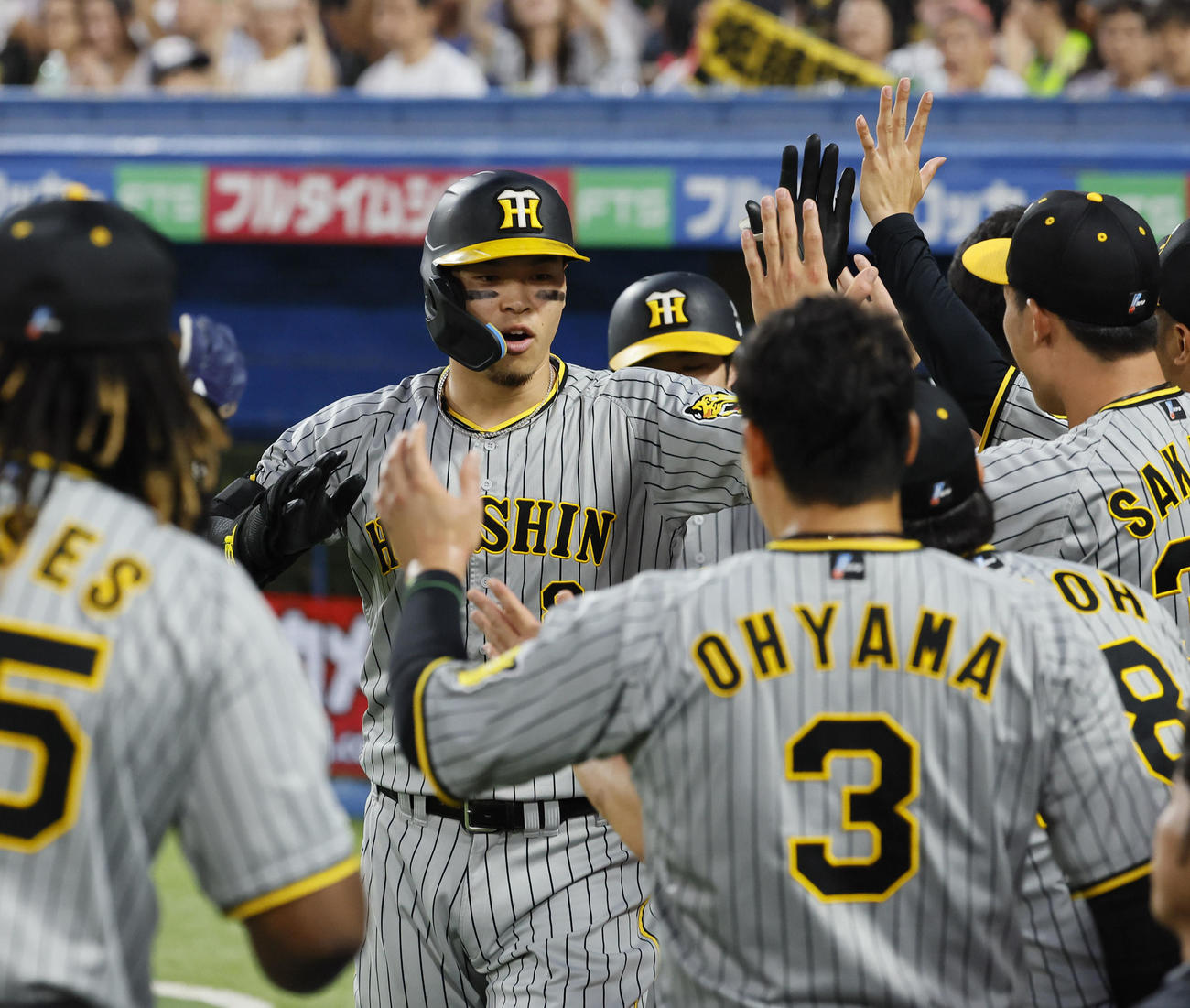 ヤクルト対阪神　1回表阪神1死二、三塁、右越えに3点本塁打を放ちナインと笑顔でタッチを交わす佐藤輝（撮影・藤尾明華）