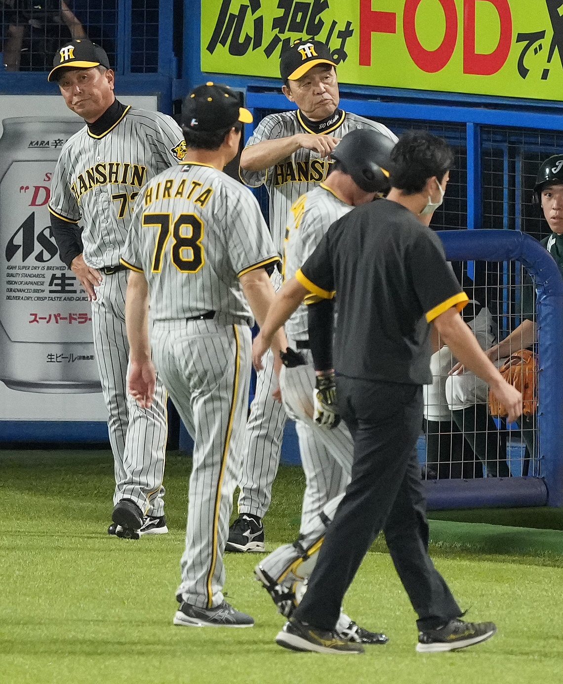 ヤクルト対阪神　9回表阪神無死、死球を受けベンチへ下がる近本（右手前から2人目）と浮かない表情の岡田監督（中央）（撮影・鈴木みどり）