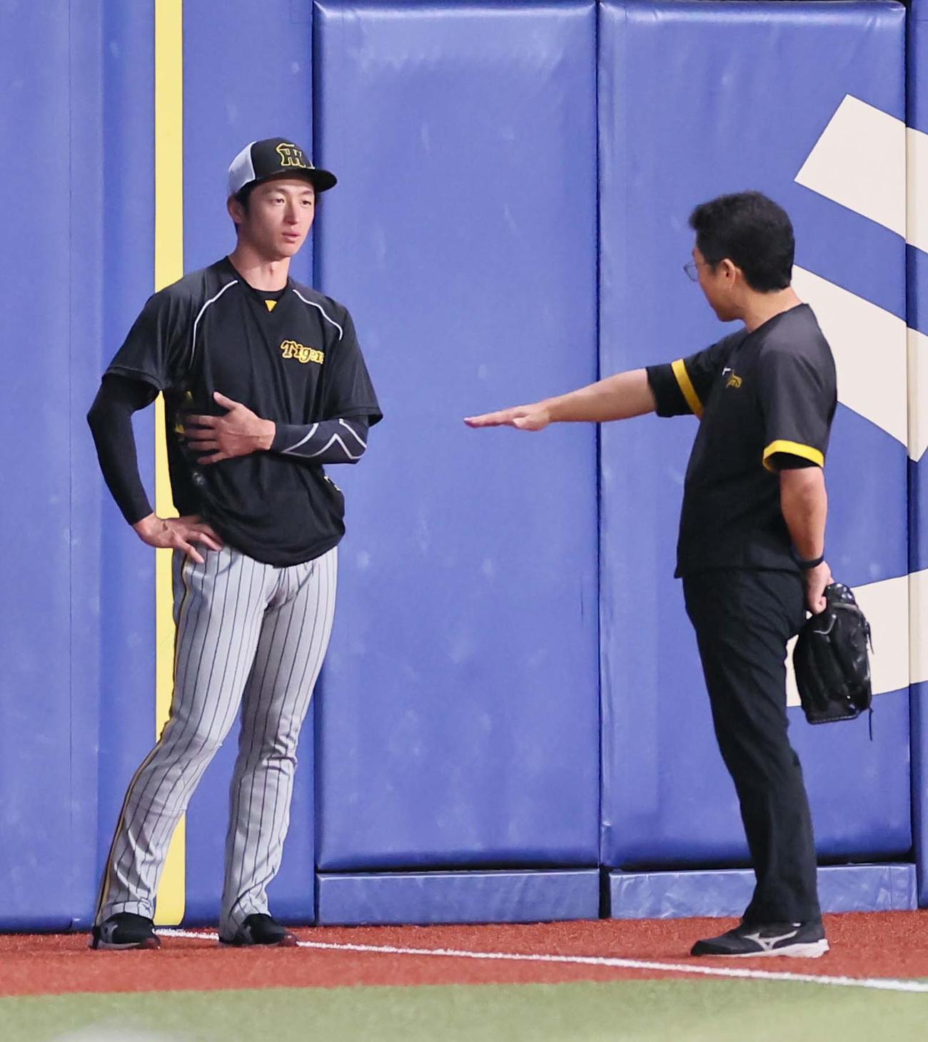 中日対阪神　脇腹を押さえながらトレーナーと話をする近本（撮影・上田博志）
