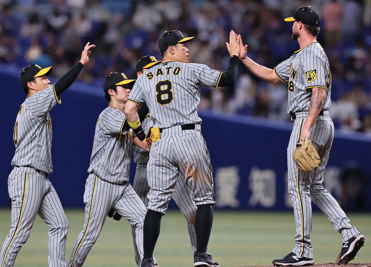 中日対阪神　佐藤輝は（中央）はナインとハイタッチして喜ぶ（撮影・上田博志）