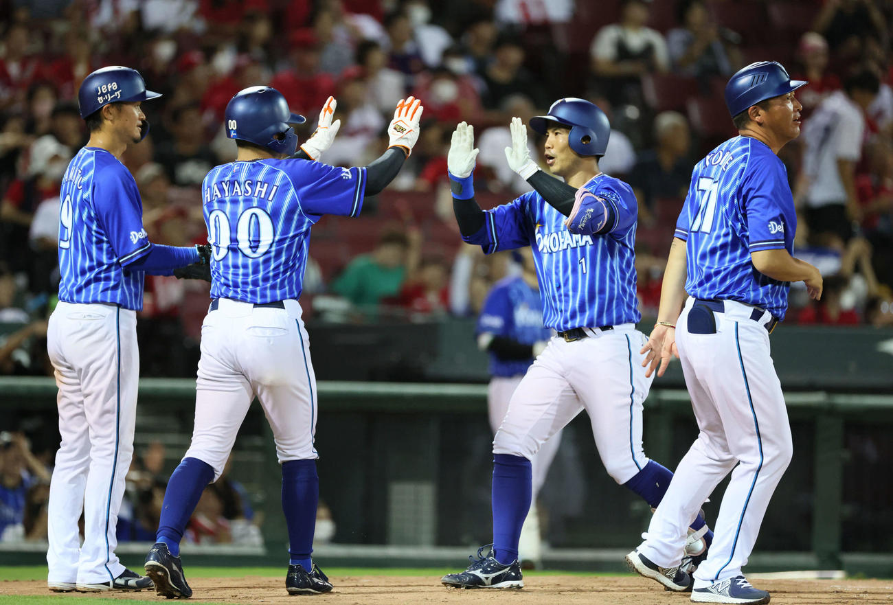 広島対DeNA 8回表DeNA2死一、二塁、同点3点本塁打を放った桑原（右から2人目）は、左から大和、林らに迎えられる（撮影・加藤孝規）