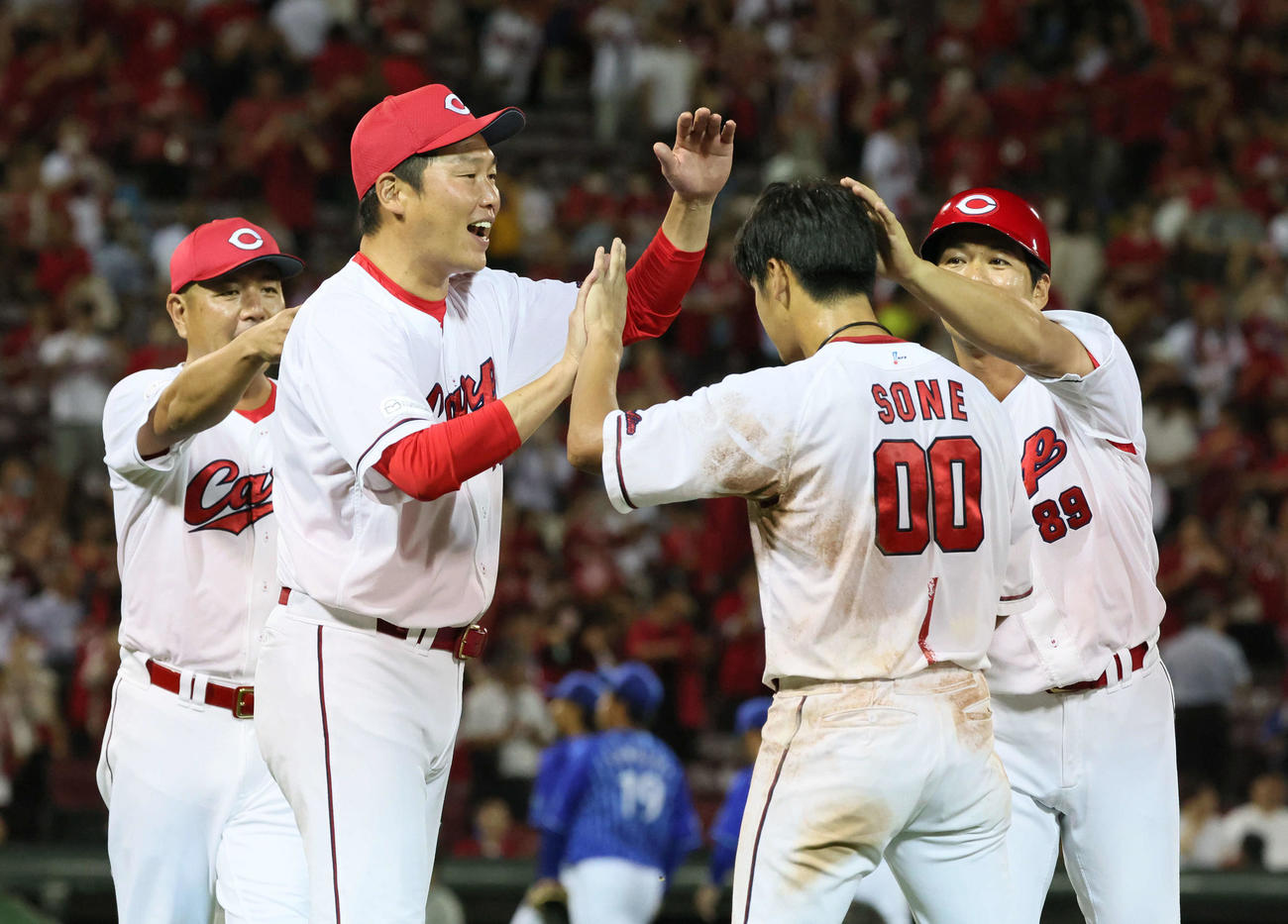 広島対DeNA　生還した曽根を迎える新井監督（左から2人目）（撮影・加藤孝規）