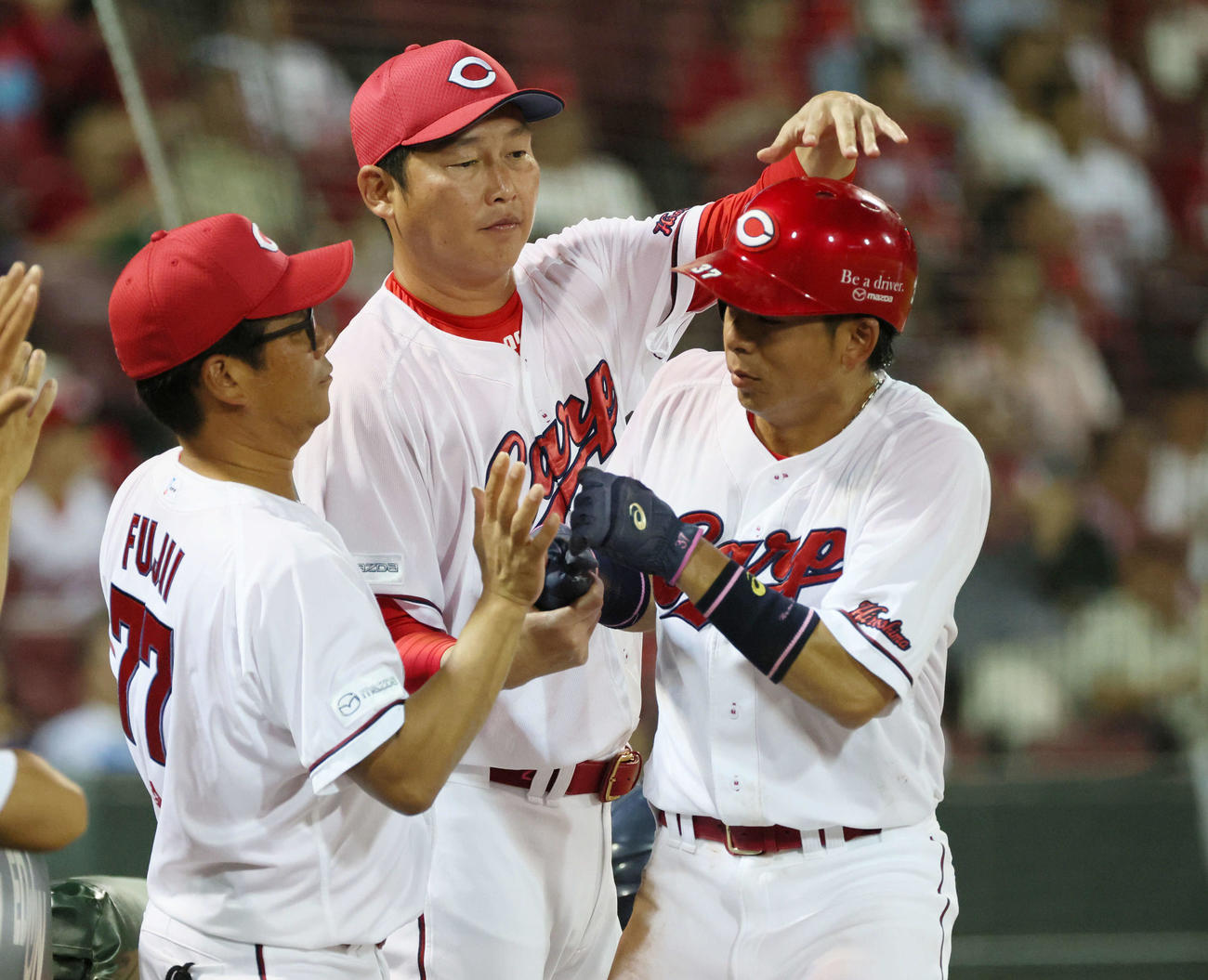 広島対DeNA 9回裏広島攻撃終了、同点打を放った野間を迎える新井監督。左は藤井ヘッドコーチ（撮影・加藤孝規）