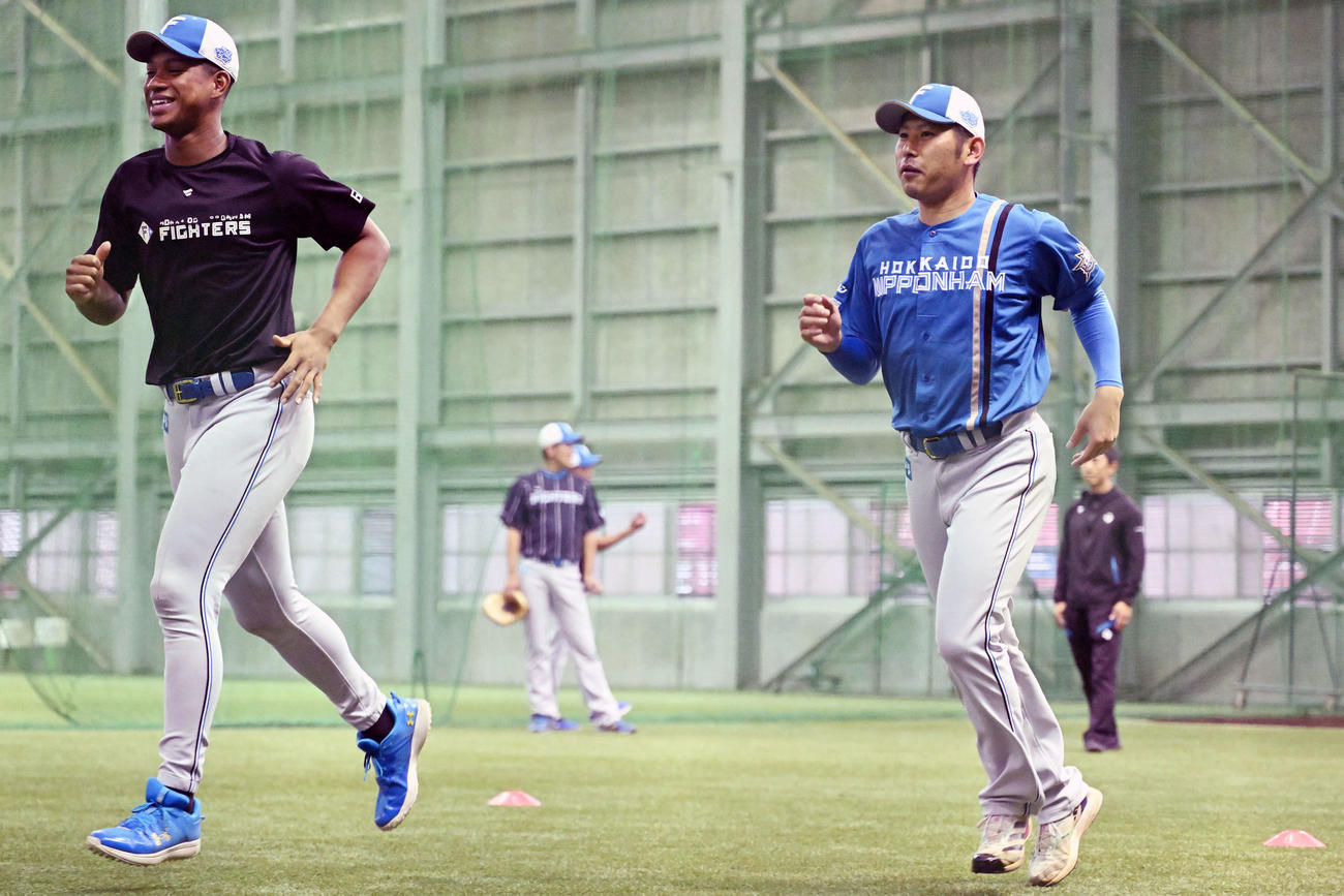 楽天対日本ハム　室内練習場で笑顔で走る日本ハム万波（左）と加藤貴（撮影・滝沢徹郎）