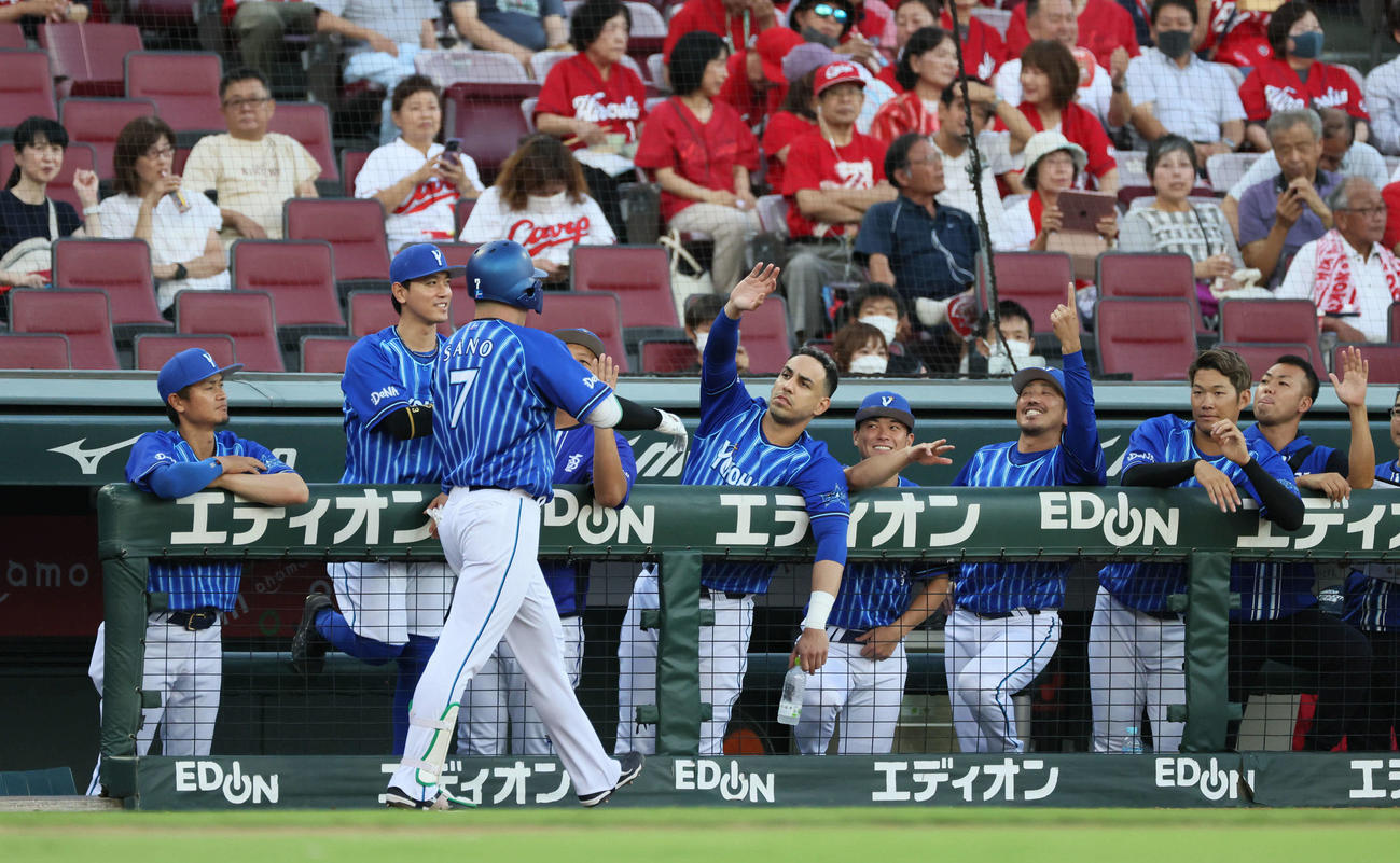 広島対DeNA 1回表DeNA2死、先制右中間本塁打を放ち、チームメートに迎えられる佐野（右）（撮影・加藤孝規）