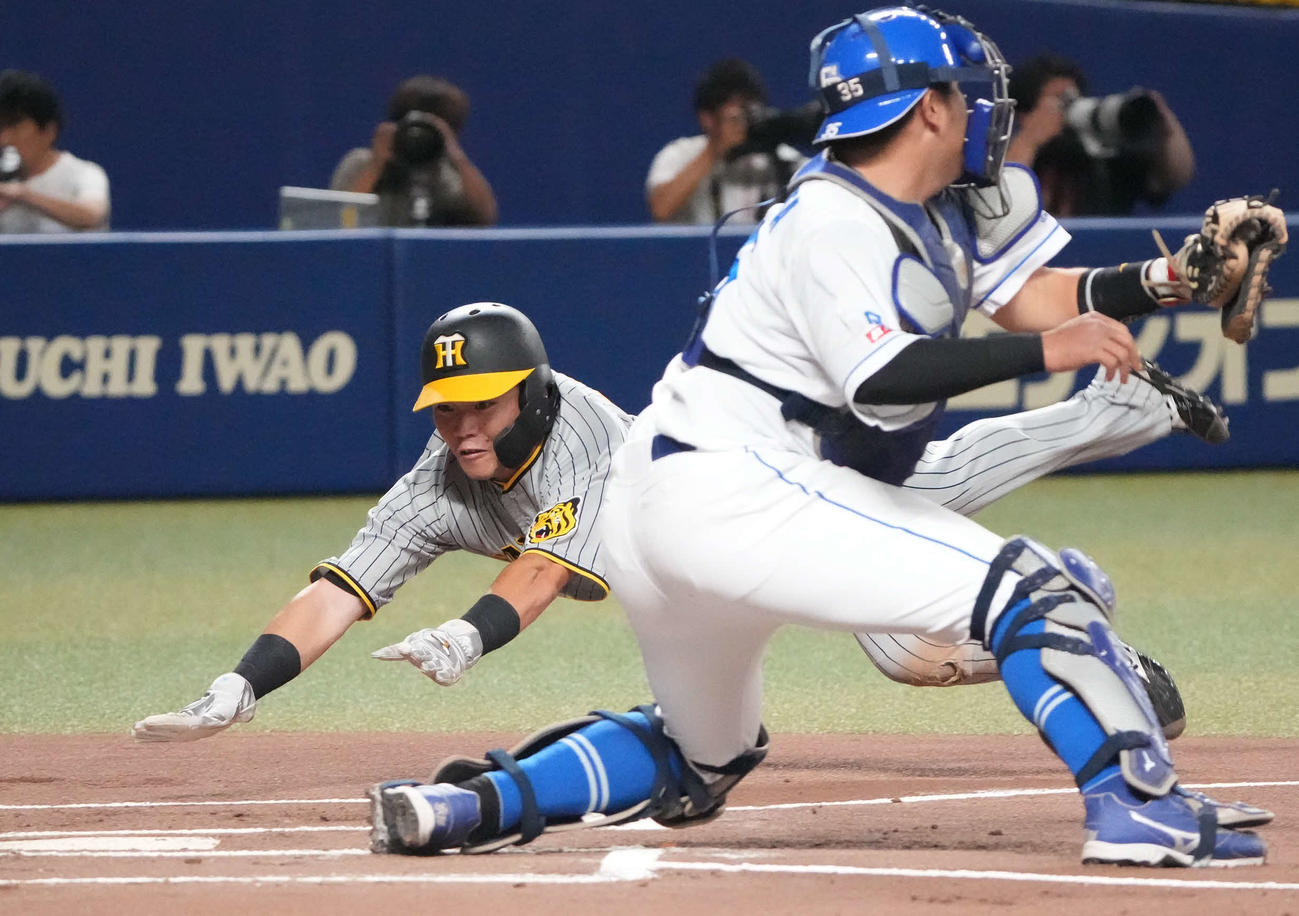 中日対阪神　1回表阪神1死二塁、森下の左前適時打で生還する小野寺（左）捕手は木下（撮影・森本幸一）