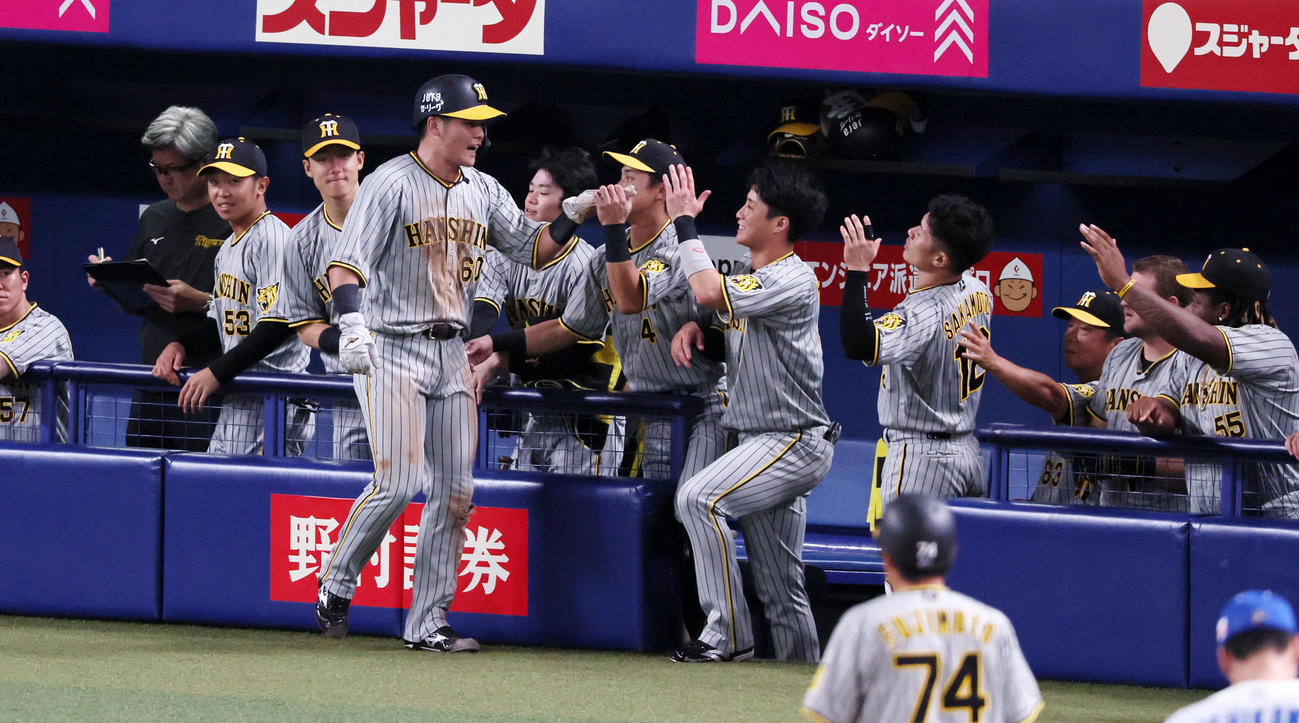 中日対阪神　1回表阪神1死二塁、二走小野寺は森下の左適時打で生還しベンチのナインとタッチする（撮影・加藤哉）