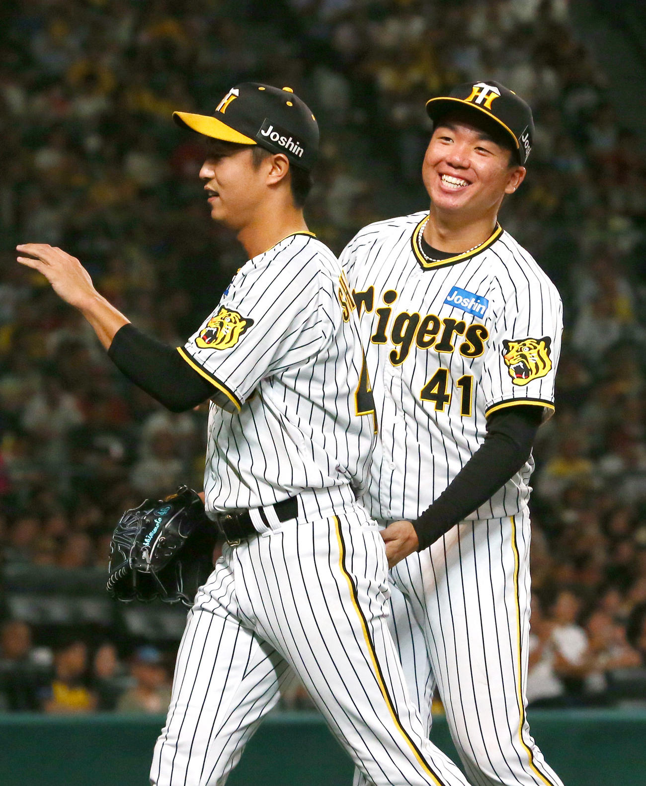 阪神対広島　8回途中で村上（右）から継投した島本は後続をキッチリ抑えナインの出迎えを受ける（撮影・上山淳一）