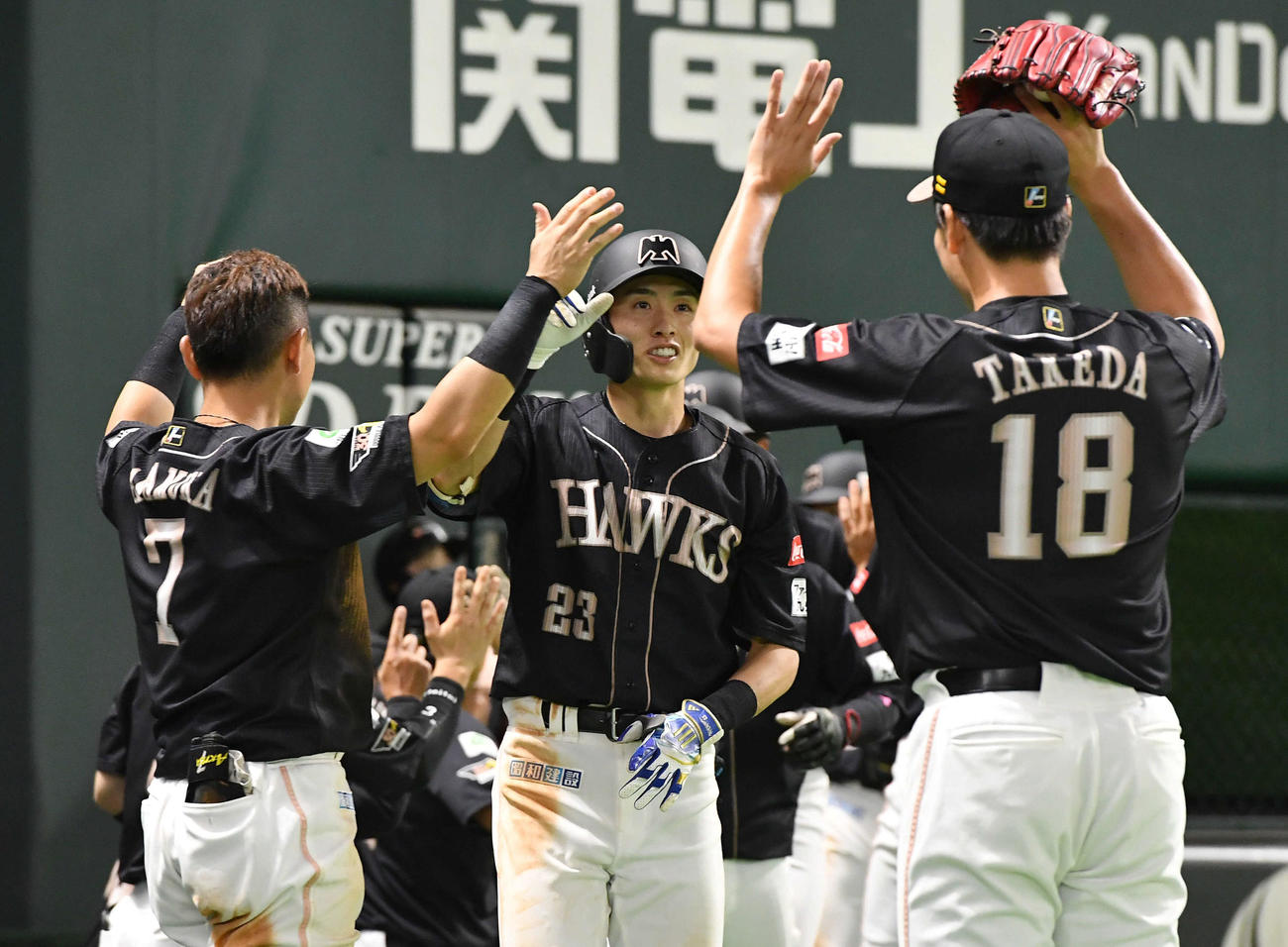 ソフトバンク対楽天　6回裏ソフトバンク2死満塁、右越え満塁本塁打を放ち、ベンチ前で中村晃（左）、武田（右）とタッチを交わす周東（撮影・岩下翔太）