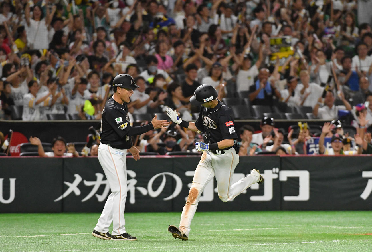 ソフトバンク対楽天　6回裏ソフトバンク2死満塁、右越え満塁本塁打を放ち、村松コーチ（左）とタッチしながら本塁へ走る周東（撮影・岩下翔太）