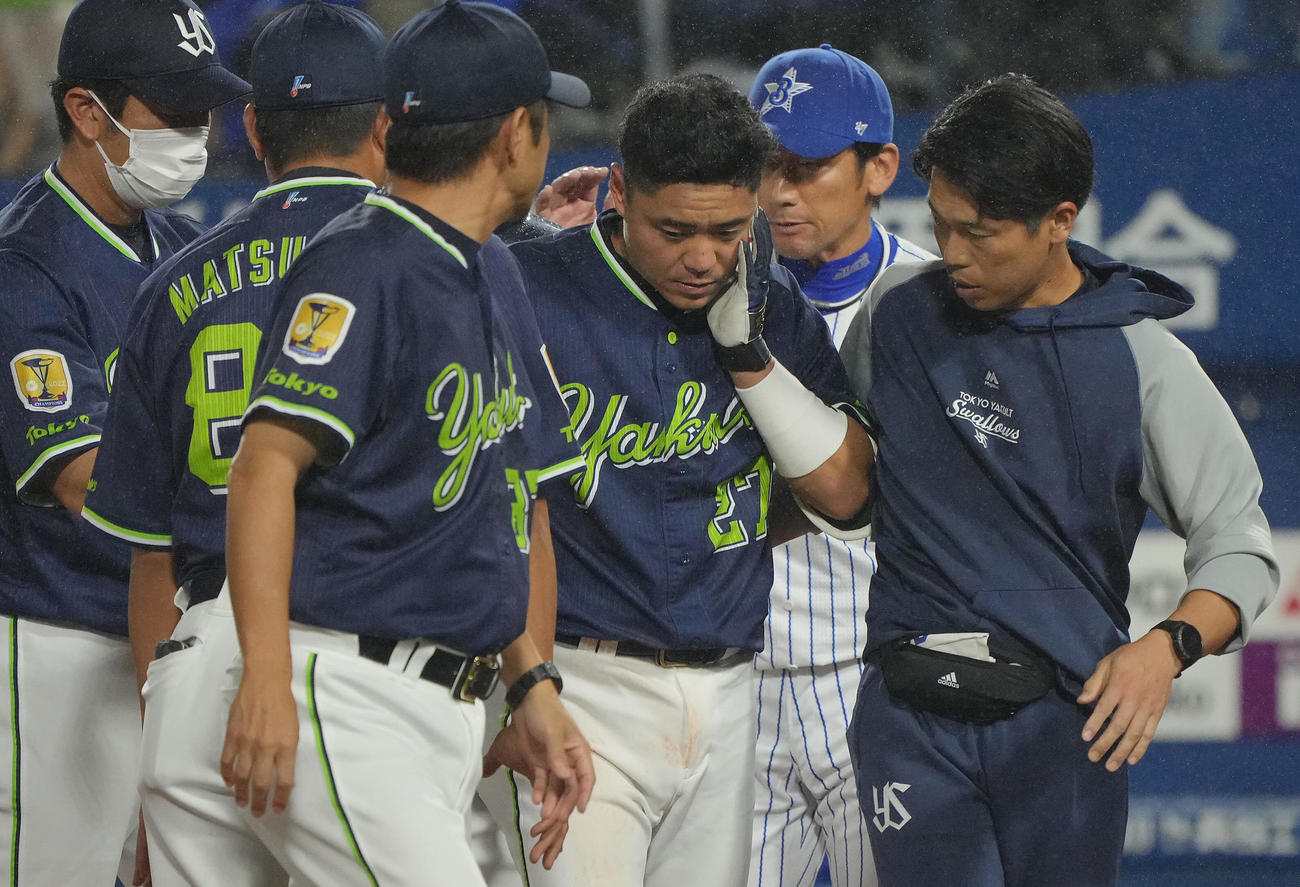 DeNA対ヤクルト　9回表ヤクルト1死一塁、頭部死球を受けた中村（中央）はスタッフとベンチ裏に下がる（撮影・垰建太）