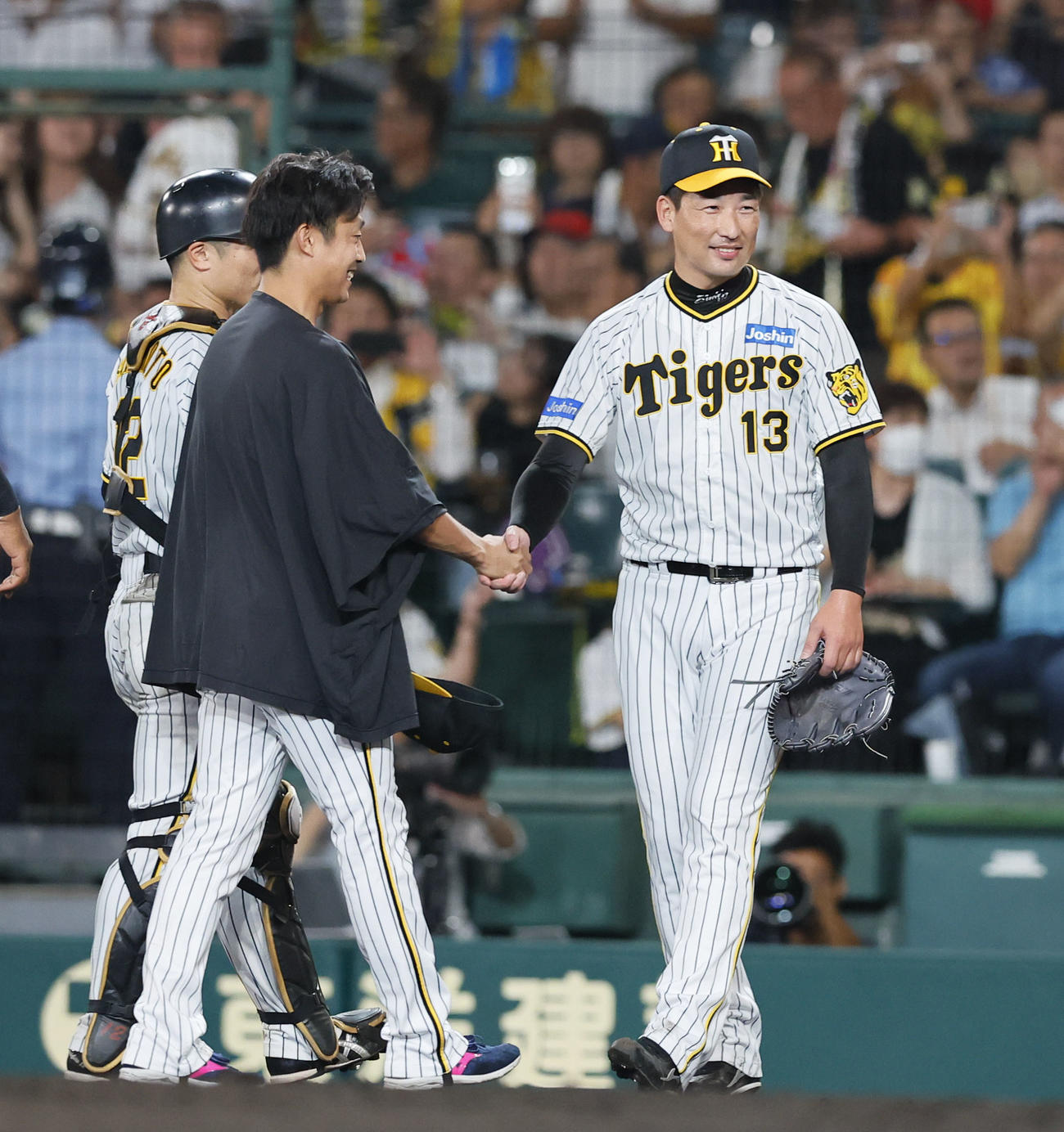 阪神対広島　広島に勝利し、島本浩也（中央）と握手を交わす阪神岩崎（右）（撮影・藤尾明華）