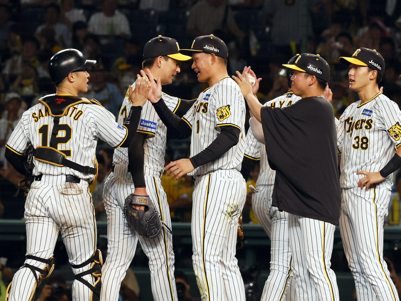 阪神対広島　10勝目を飾り岩崎（左から2人目）からウイニングボールを受け取る阪神村上（右から2人目）（撮影・藤尾明華）