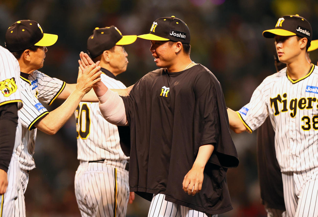 阪神対広島　阪神村上（手前）は10勝目を挙げタッチをかわす（撮影・上山淳一）