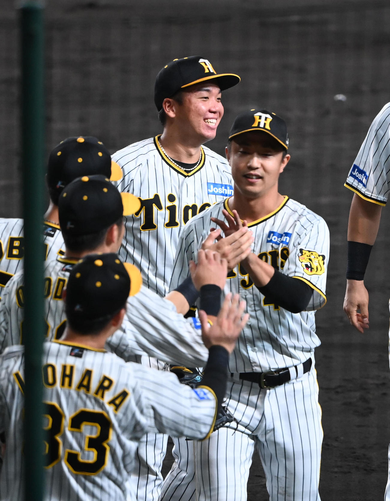 阪神対広島　8回、ピンチを抑えた島本（右）を笑顔で迎えた村上（撮影・前岡正明）