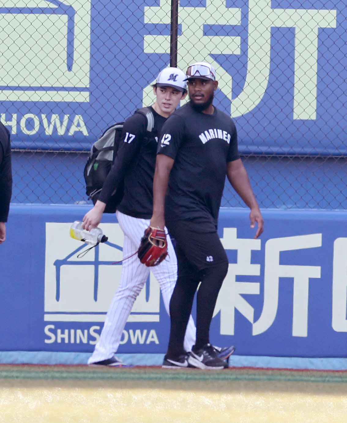ロッテ対オリックス　アップを終え引き揚げるロッテ佐々木朗（左）（撮影・鈴木正人）