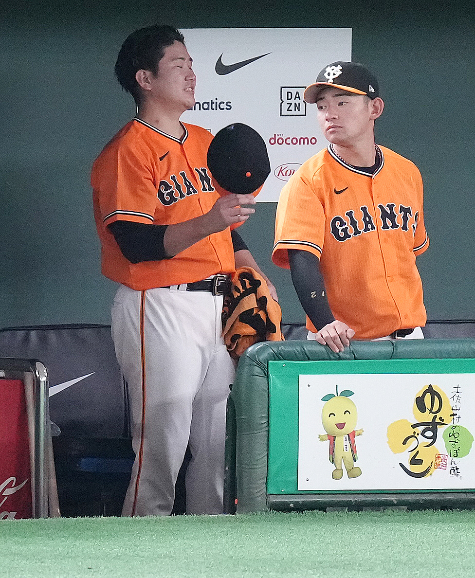 巨人対中日　6回表に1球も投げずに降板し、ベンチで浮かない表情の巨人菅野（左）（撮影・鈴木みどり）