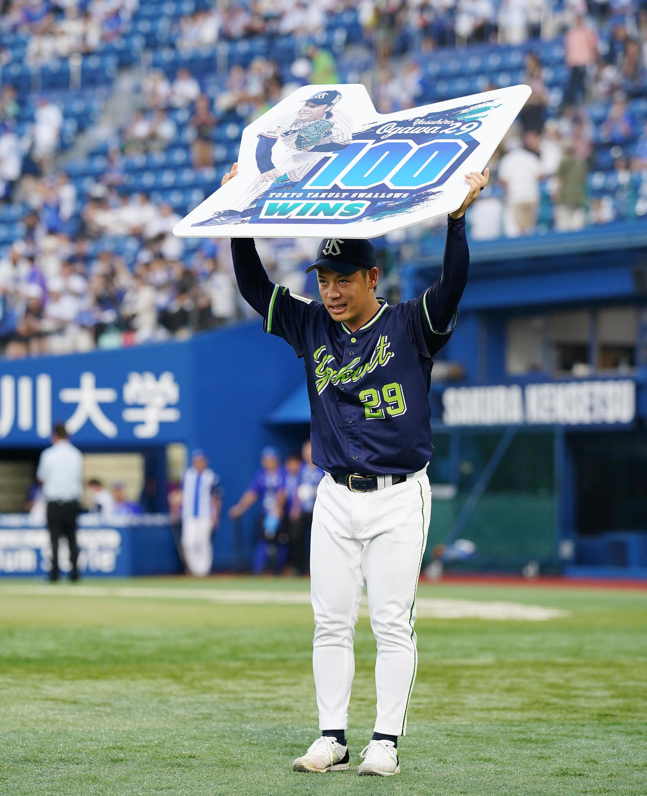 DeNA対ヤクルト　通算100勝を達成し記念ボードを手にファンに一礼するヤクルト小川（撮影・垰建太）