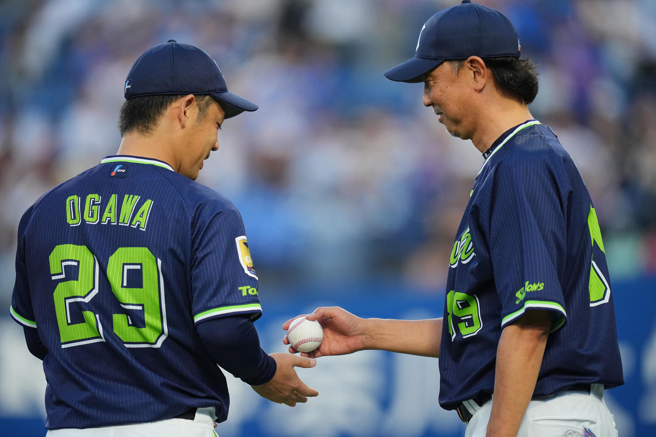 DeNA対ヤクルト　DeNAに勝利し、伊藤投手コーチ（右）から通算100勝目の勝利球をもらう小川（撮影・垰建太）