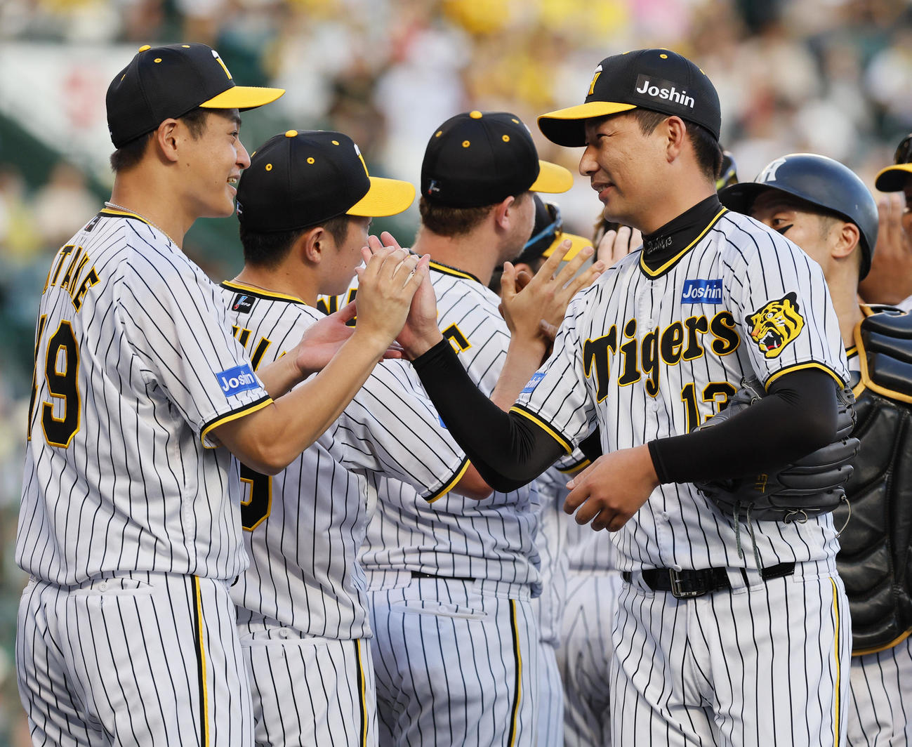 阪神対広島　10勝目を飾り、岩崎優（手前右）からウイニングボールを受け取る阪神大竹耕太郎（左端）（撮影・藤尾明華）