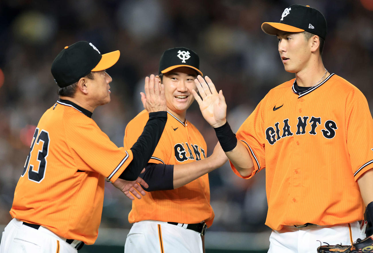 巨人対中日　4勝目を挙げた巨人菅野（中央）は、原監督（左）と笑顔で秋広らナインを迎える（撮影・浅見桂子）