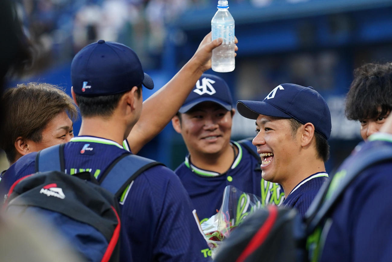 DeNA対ヤクルト　通算100勝を達成したヤクルト小川（右）はチームメートの祝福に笑顔を見せる（撮影・垰建太）