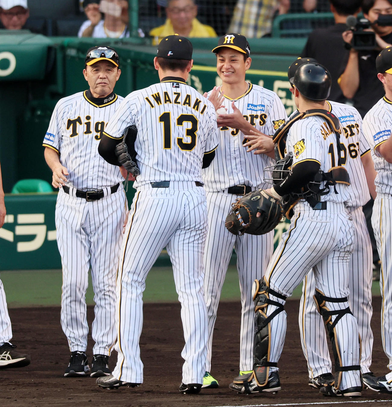 阪神対広島　広島に勝利し岩崎（左）からウイニングボールを手渡される大竹。左端は岡田監督（撮影・加藤哉）