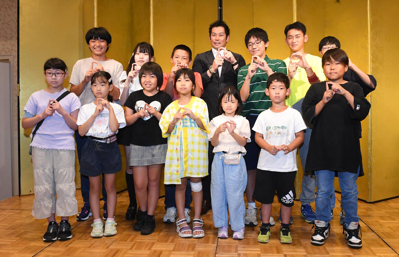 阪神タイガース戦親子観戦会で参加者の子どもたちと記念撮影を行う本紙評論家の岩田稔氏（撮影・前岡正明）