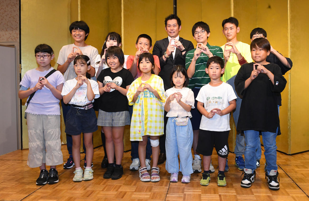 阪神タイガース戦親子観戦会で参加者の子どもたちと記念撮影を行う本紙評論家の岩田稔氏（撮影・前岡正明）