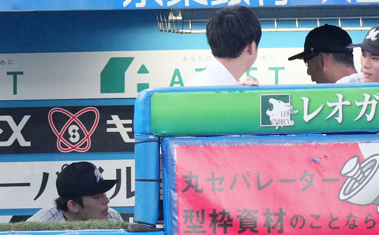 ロッテ対オリックス　3回表終了後、ベンチで言葉を交わすロッテ佐々木朗（左）と吉井監督（同3人目）（撮影・横山健太）