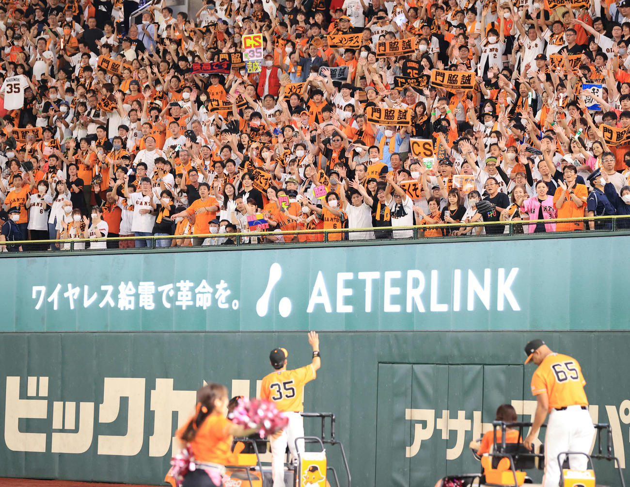巨人対中日　3連勝で「CS行くぞ」のボードを掲げるスタンドに手を振る巨人門脇（左）とメンデス（撮影・浅見桂子）